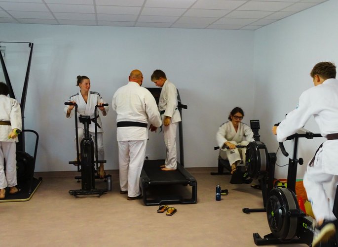Professeur et élèves de judo entrain de s'entrainer dans une salle de sport