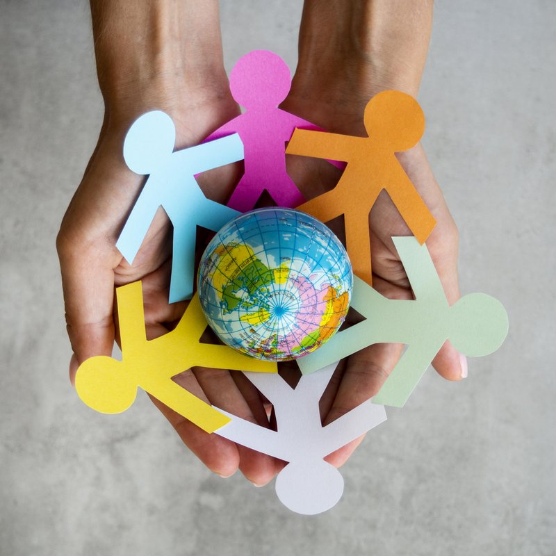Bonhommes en papier coloré autour d'un globe