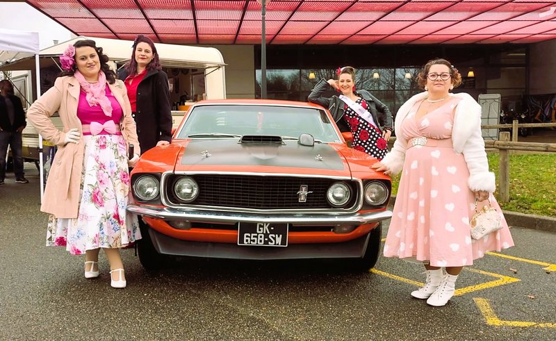 4 femmes habillées comme dans les années 1950 autour d'une mustang vintage